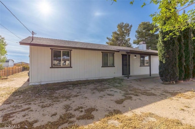 single story home featuring fence and a chimney