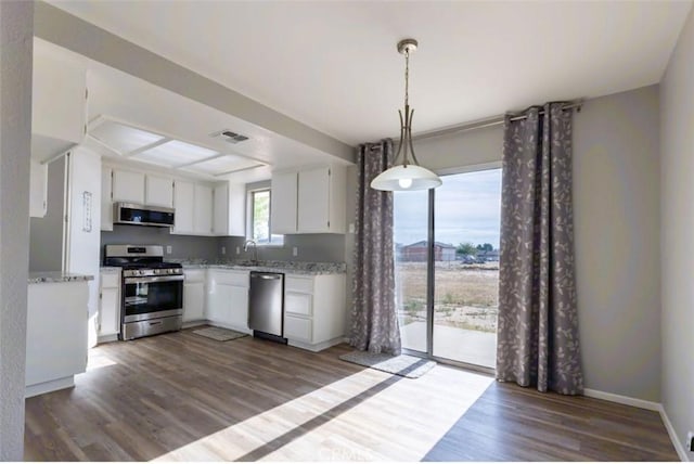 kitchen featuring appliances with stainless steel finishes, a sink, white cabinets, and dark wood-type flooring
