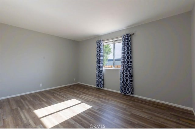unfurnished room with wood finished floors and baseboards