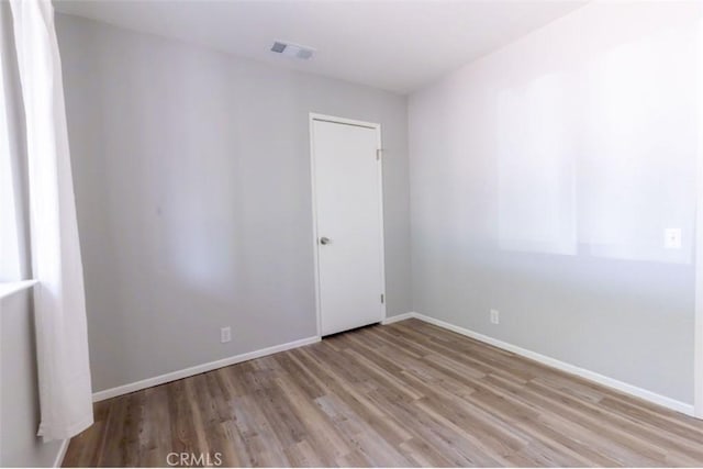 unfurnished room with wood finished floors and baseboards