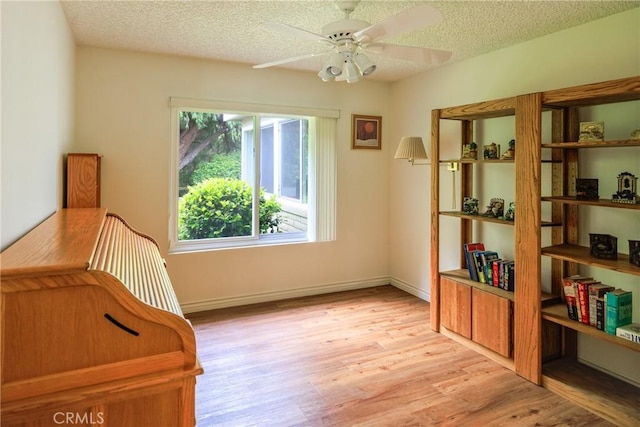 3268 San Amadeo Unit C, Laguna Woods, CA 92637 - sitting room featuring light wood finished floors, a ceiling fan, a textured ceiling, and baseboards