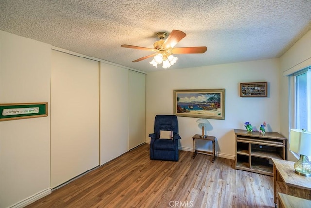 3268 San Amadeo Unit C, Laguna Woods, CA 92637 - sitting room featuring wood finished floors, ceiling fan, a textured ceiling, and baseboards