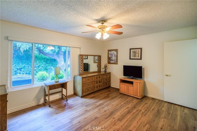 3268 San Amadeo Unit C, Laguna Woods, CA 92637 - sitting room with light wood-type flooring, ceiling fan, a textured ceiling, and baseboards