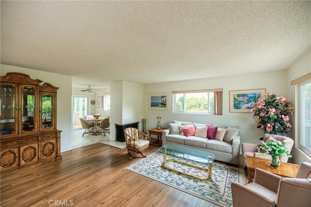3268 San Amadeo Unit C, Laguna Woods, CA 92637 - living room featuring a textured ceiling, healthy amount of natural light, wood finished floors, and ceiling fan