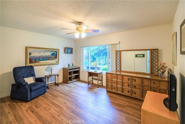 3268 San Amadeo Unit C, Laguna Woods, CA 92637 - sitting room with wood finished floors, ceiling fan, a textured ceiling, and baseboards