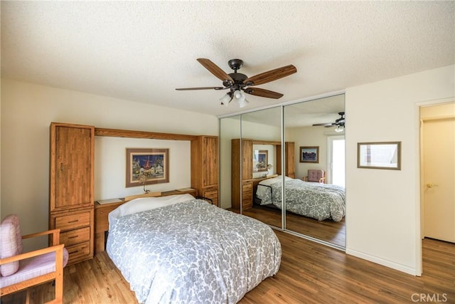 3268 San Amadeo Unit C, Laguna Woods, CA 92637 - bedroom featuring wood finished floors, a closet, ceiling fan, a textured ceiling, and baseboards