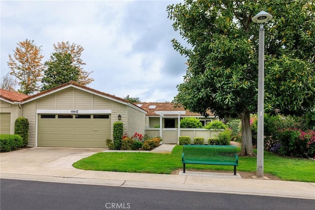 3268 San Amadeo Unit C, Laguna Woods, CA 92637 - view of front facade featuring a tiled roof, driveway, an attached garage, and a front lawn