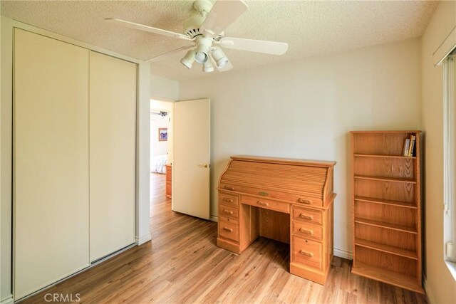 3268 San Amadeo Unit C, Laguna Woods, CA 92637 - bedroom featuring light wood-type flooring, a textured ceiling, a ceiling fan, and a closet