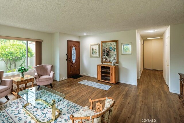 3268 San Amadeo Unit C, Laguna Woods, CA 92637 - living area featuring a textured ceiling, wood finished floors, baseboards, and recessed lighting