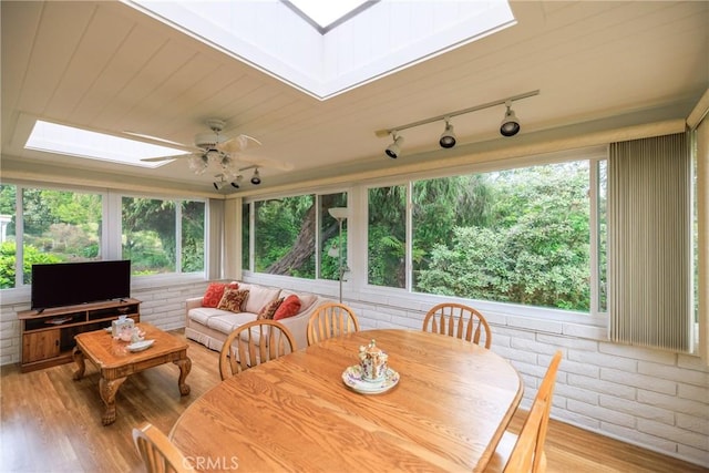 3268 San Amadeo Unit C, Laguna Woods, CA 92637 - sunroom with a skylight, rail lighting, plenty of natural light, wood finished floors, and brick wall