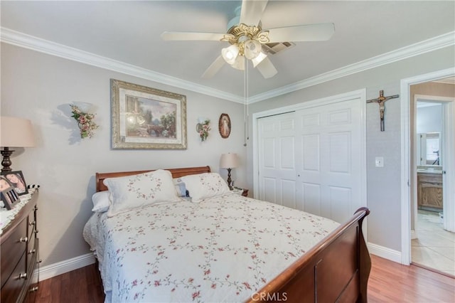 bedroom with baseboards, a closet, wood finished floors, ornamental molding, and ceiling fan