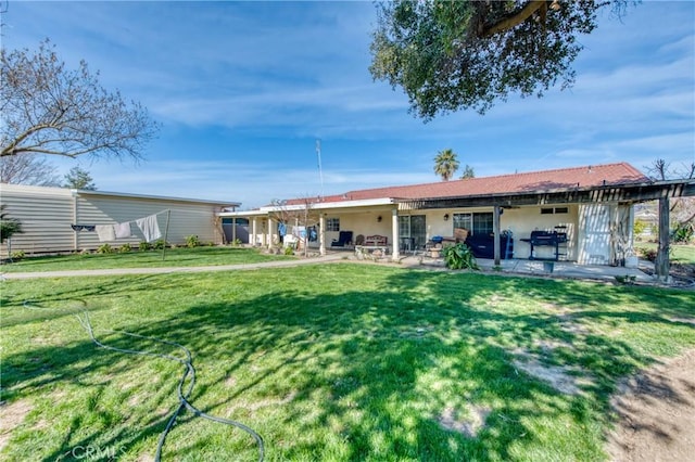 back of house featuring a patio and a lawn