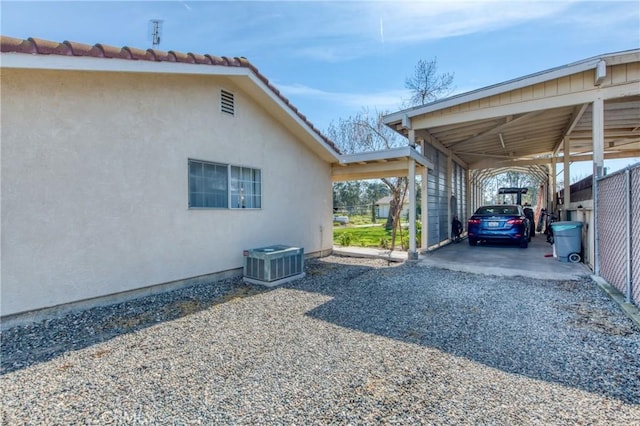 view of parking featuring a carport and gravel driveway