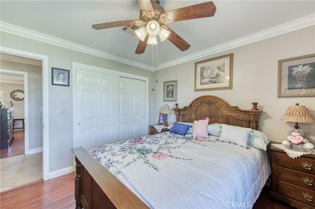 bedroom featuring crown molding, wood finished floors, a closet, baseboards, and ceiling fan