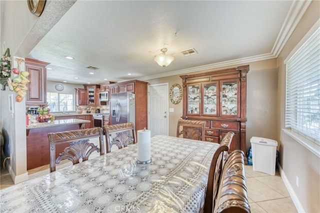 dining room featuring light tile patterned floors, baseboards, recessed lighting, and crown molding