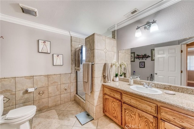 full bathroom with tile patterned floors, a shower with shower door, crown molding, toilet, and tile walls
