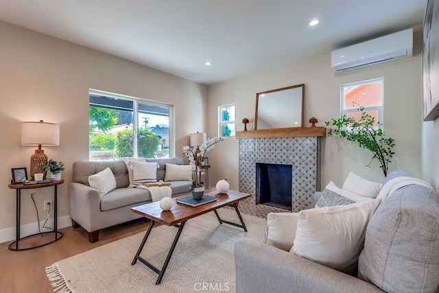 1847 W 74th St, Los Angeles, CA 90047 - living area featuring a wall mounted AC, light wood-type flooring, a tiled fireplace, recessed lighting, and baseboards
