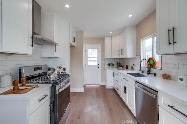 1847 W 74th St, Los Angeles, CA 90047 - kitchen with appliances with stainless steel finishes, a sink, wall chimney exhaust hood, healthy amount of natural light, and recessed lighting