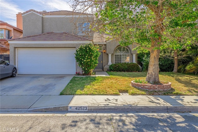 traditional-style home featuring stucco siding, concrete driveway, a front yard, a tiled roof, and a garage