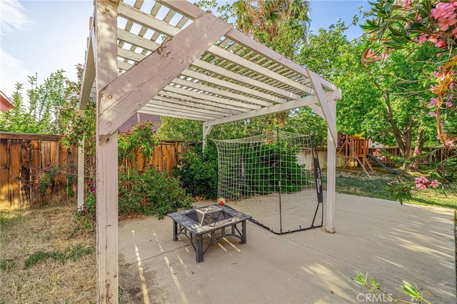 view of patio / terrace featuring a fenced backyard, a pergola, a playground, and an outdoor fire pit