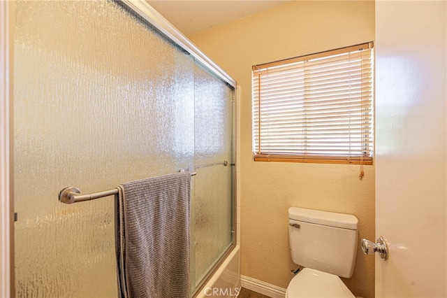 full bath with toilet and bath / shower combo with glass door