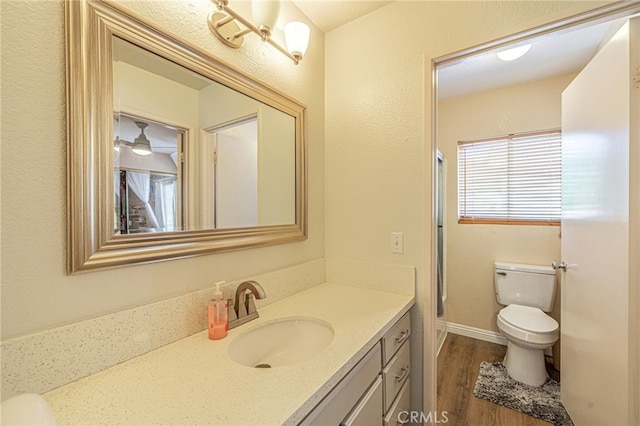 bathroom featuring toilet, wood finished floors, and vanity