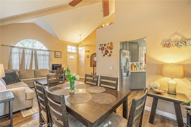 dining room with wood finished floors, vaulted ceiling, baseboards, and a ceiling fan