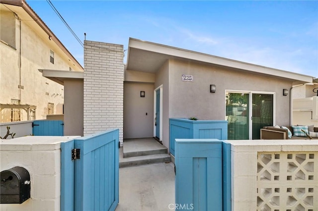 225 S Guadalupe Ave, Redondo Beach, CA 90277 - view of exterior entry with a gate, stucco siding, and fence