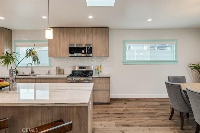 225 S Guadalupe Ave, Redondo Beach, CA 90277 - kitchen with appliances with stainless steel finishes, a sink, light countertops, decorative backsplash, and light wood-style flooring