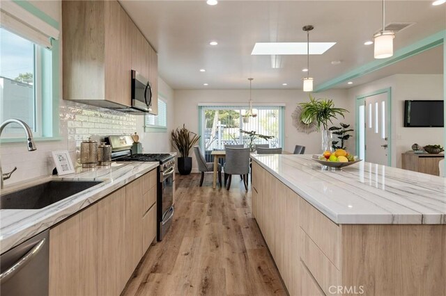 225 S Guadalupe Ave, Redondo Beach, CA 90277 - kitchen with appliances with stainless steel finishes, modern cabinets, light brown cabinetry, a sink, and light wood finished floors