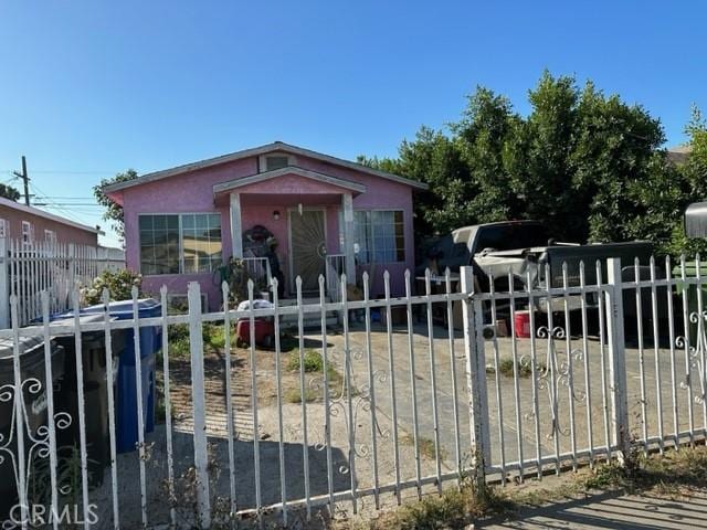 bungalow-style home with a fenced front yard and a gate
