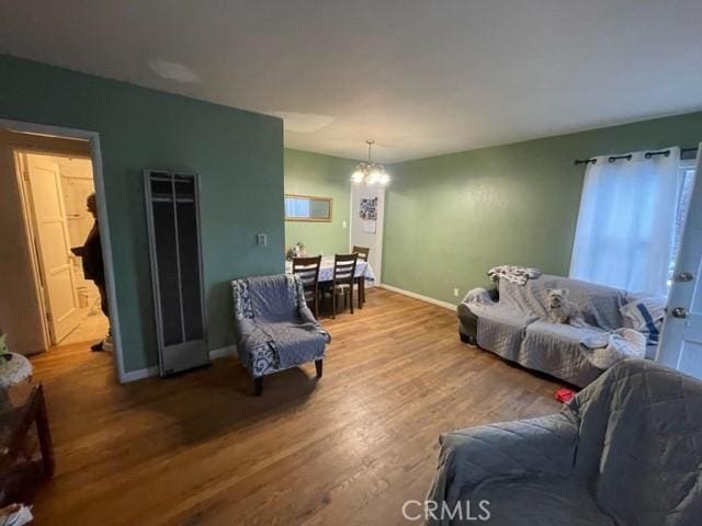 6705 Denny Ave, North Hollywood, CA 91606 - living room featuring a heating unit, a chandelier, wood finished floors, and baseboards