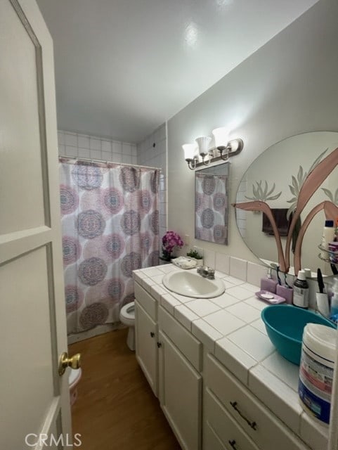 6705 Denny Ave, North Hollywood, CA 91606 - full bathroom with wood finished floors, double vanity, toilet, a shower with curtain, and a chandelier