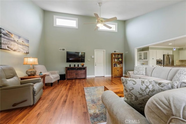 17152 Friml Ln, Huntington Beach, CA 92649 - living room with a high ceiling, a ceiling fan, light wood-type flooring, and baseboards