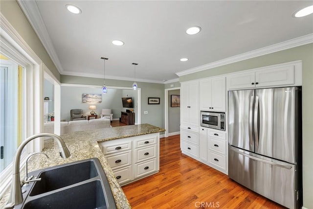 17152 Friml Ln, Huntington Beach, CA 92649 - kitchen featuring appliances with stainless steel finishes, a sink, light wood finished floors, ornamental molding, and white cabinetry