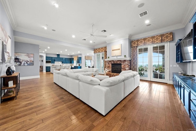 3401 Adams Run, Encinitas, CA 92024 - living area featuring a ceiling fan, a glass covered fireplace, ornamental molding, hardwood / wood-style flooring, and baseboards