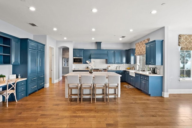 3401 Adams Run, Encinitas, CA 92024 - kitchen with built in microwave, blue cabinetry, a sink, arched walkways, and open shelves