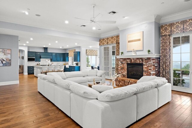3401 Adams Run, Encinitas, CA 92024 - living area with ornamental molding, plenty of natural light, a ceiling fan, a brick fireplace, and hardwood / wood-style floors