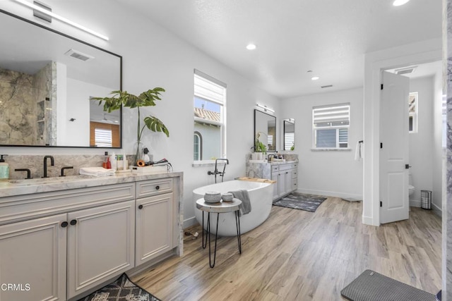4173 Caribbean St, Oxnard, CA 93035 - full bath with wood finished floors, plenty of natural light, recessed lighting, two vanities, and baseboards