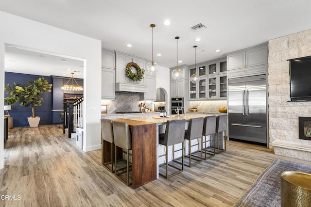 4173 Caribbean St, Oxnard, CA 93035 - kitchen with stainless steel appliances, light wood finished floors, backsplash, a breakfast bar, and recessed lighting