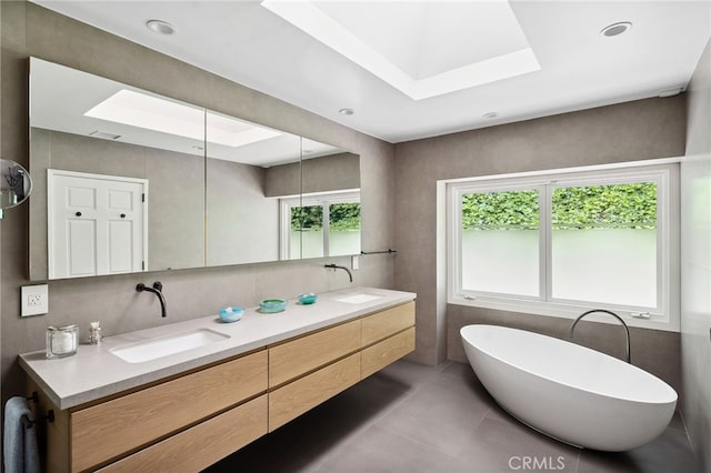 3818 Hollyline Ave, Sherman Oaks, CA 91423 - full bath featuring a skylight, a freestanding tub, tile patterned flooring, double vanity, and a raised ceiling