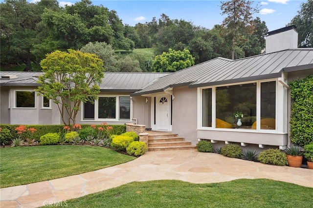 3818 Hollyline Ave, Sherman Oaks, CA 91423 - view of front of house with a standing seam roof, metal roof, a front lawn, stucco siding, and a chimney