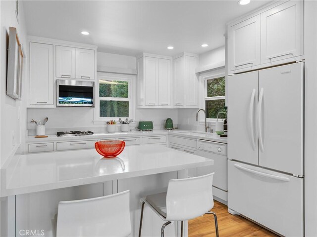 3818 Hollyline Ave, Sherman Oaks, CA 91423 - kitchen with white appliances, a sink, plenty of natural light, recessed lighting, and a kitchen breakfast bar