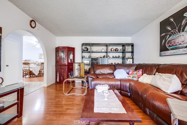 25681 Westover Cir, Lake Forest, CA 92630 - living area with arched walkways, wood finished floors, and a textured ceiling