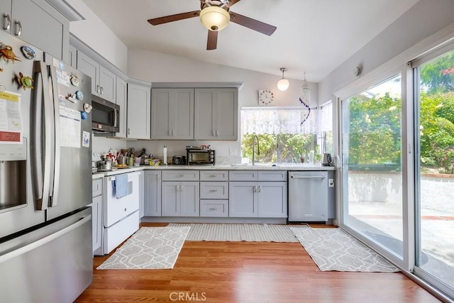25681 Westover Cir, Lake Forest, CA 92630 - kitchen featuring appliances with stainless steel finishes, gray cabinets, a sink, lofted ceiling, and light countertops