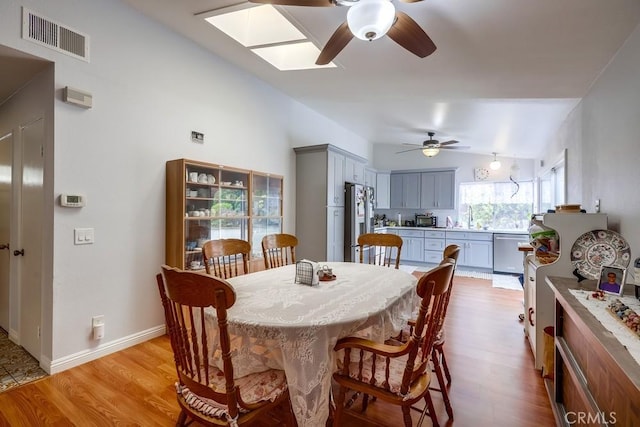 25681 Westover Cir, Lake Forest, CA 92630 - dining area featuring lofted ceiling, ceiling fan, light wood-type flooring, and a skylight