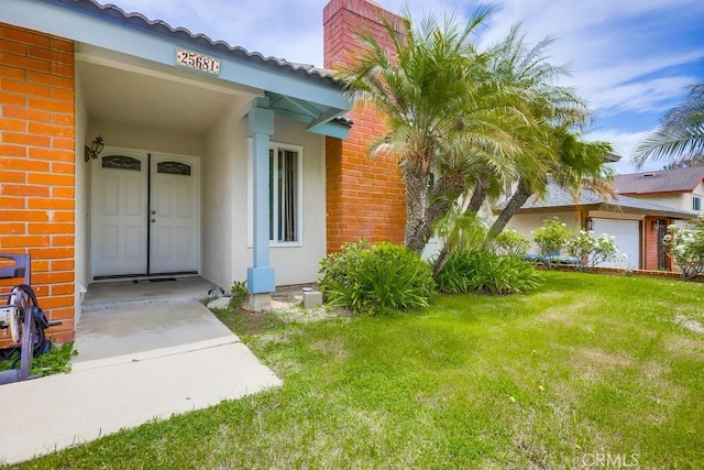 25681 Westover Cir, Lake Forest, CA 92630 - view of exterior entry featuring brick siding, a yard, a chimney, and stucco siding