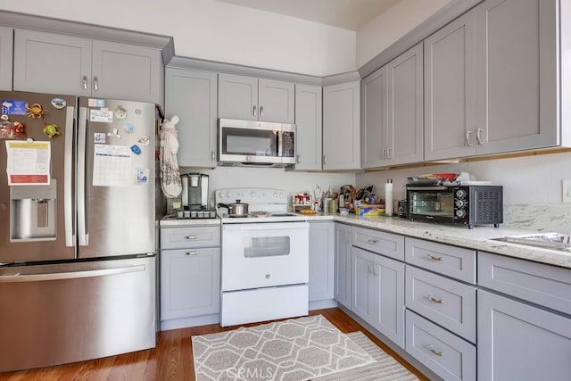25681 Westover Cir, Lake Forest, CA 92630 - kitchen with stainless steel appliances, gray cabinetry, light wood-style flooring, and light stone countertops