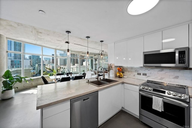 1080 Park Blvd Unit 701, San Diego, CA 92101 - kitchen with stainless steel appliances, a sink, a peninsula, white cabinets, and decorative backsplash