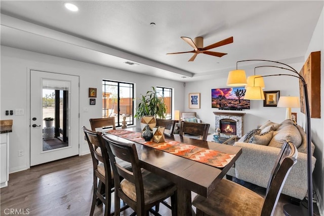 58183 Canterbury St, Yucca Valley, CA 92284 - dining space featuring ceiling fan, a fireplace, dark wood finished floors, recessed lighting, and a tray ceiling